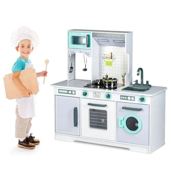 Niño con delantal de chef junto a la cocina de juguete gris y blanca Angelove