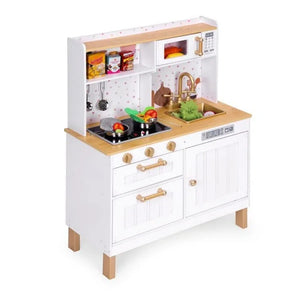 Photo studio inclinée de la cuisine jouet interactive en bois Angelove avec finition blanche, plan de travail en bois naturel, accents dorés et plaques de cuisson LED, stylisée avec des aliments jouets.