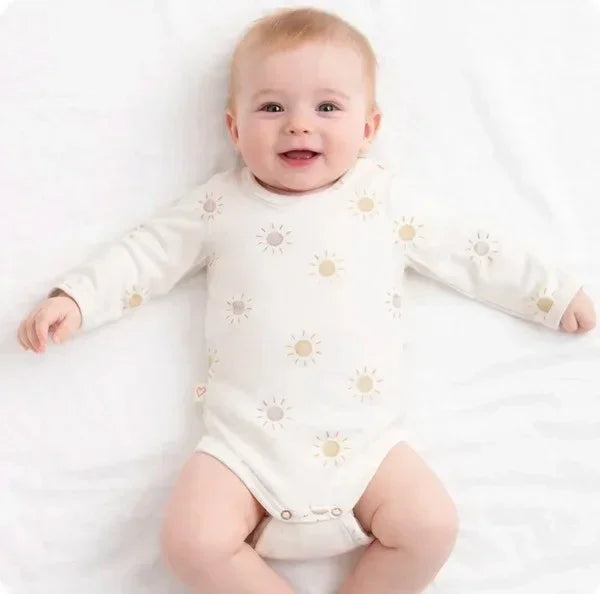 long sleeve baby bodysuit with sun print pattern in neutral tones on white background