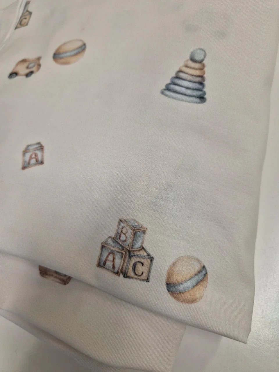 Body neutre pour bébé avec motif jouets pastel et blocs ABC sur coton