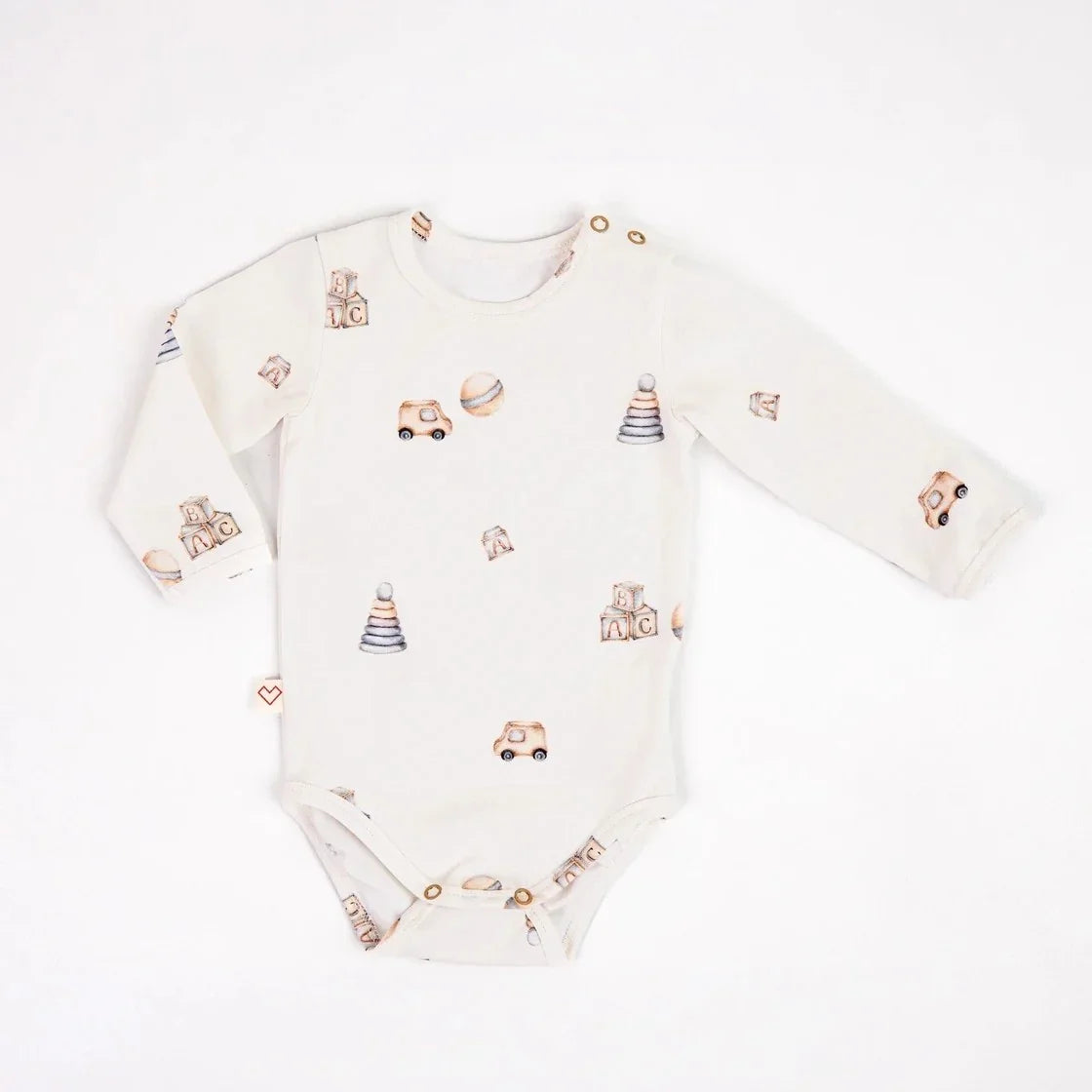 Long sleeve baby bodysuit with beige toy car, blocks, and stacking ring pattern on white cotton