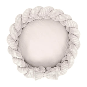 Round baby nest play mat with braided crib bumper in vanilla corduroy fabric, top view
