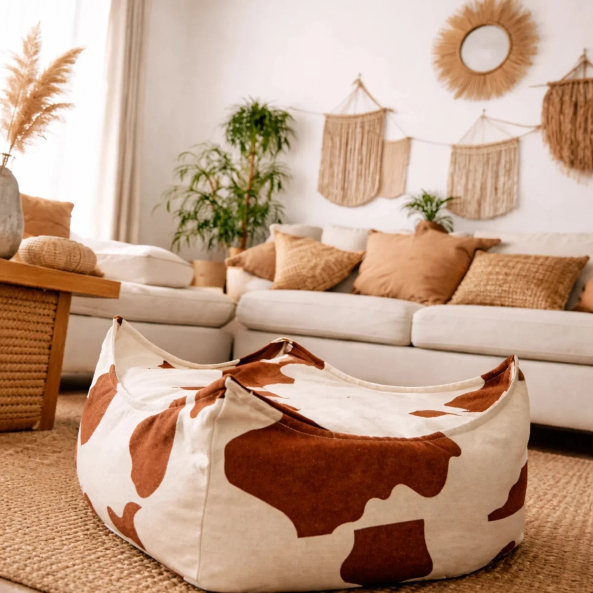 Pouf carré à motif vache pour enfant dans un salon neutre à la déco bohème
