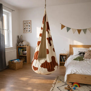 Balancelle cocon à motif vache pour enfant, suspendue dans une chambre moderne et douillette