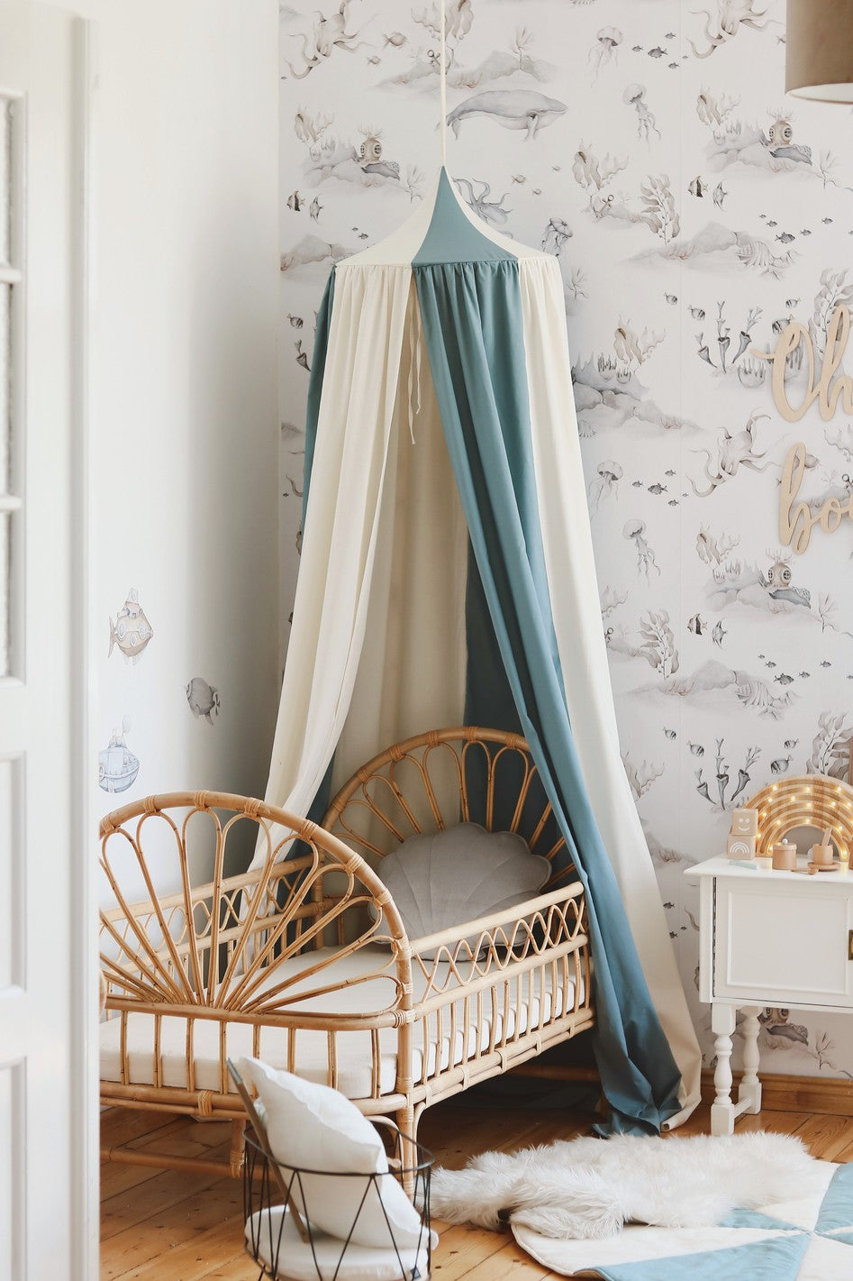 Moi Mili Blue Circus canopy styled above a natural rattan child’s bed in an ocean-themed nursery