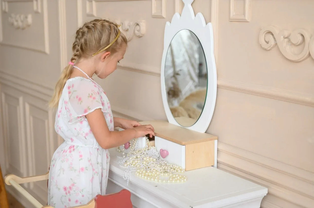 Child using white Crown Beauty Table and opening the storage drawers beside the mirror