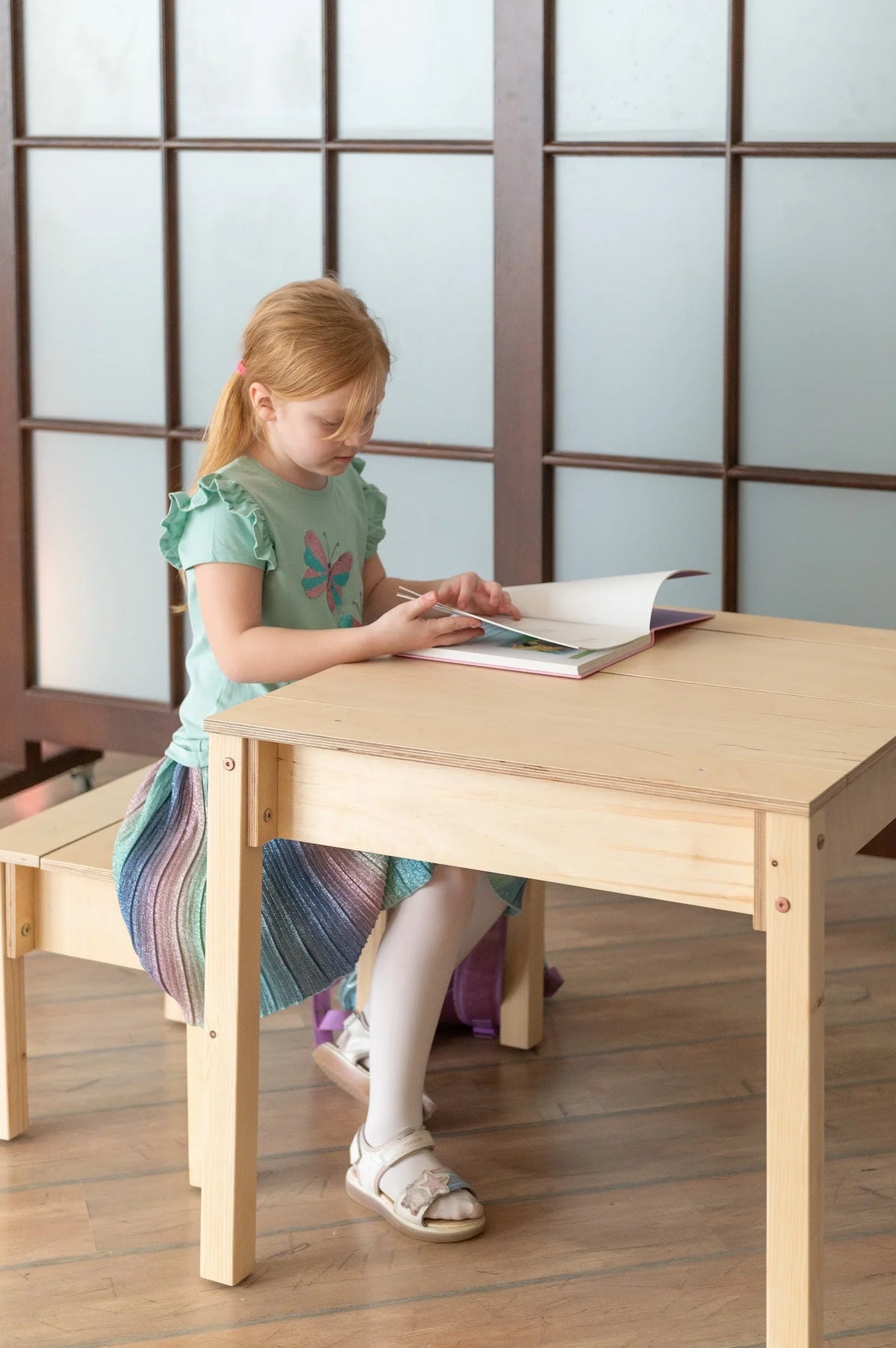 Child reading at natural birch FAMILY Smart Storage Table and Chair
