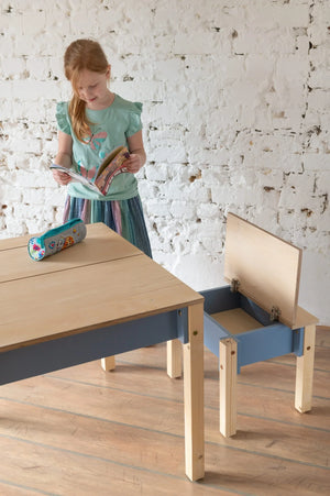 Child reading beside Dusty Blue Smart Storage Table and open storage chair