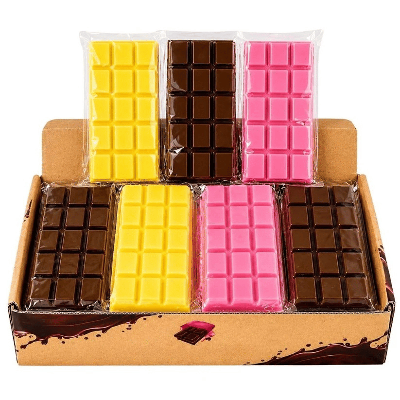 A cardboard display box containing six squishy chocolate bars in clear plastic wrapping, arranged in two rows. The bars are in three colors: yellow, dark brown, and pink.