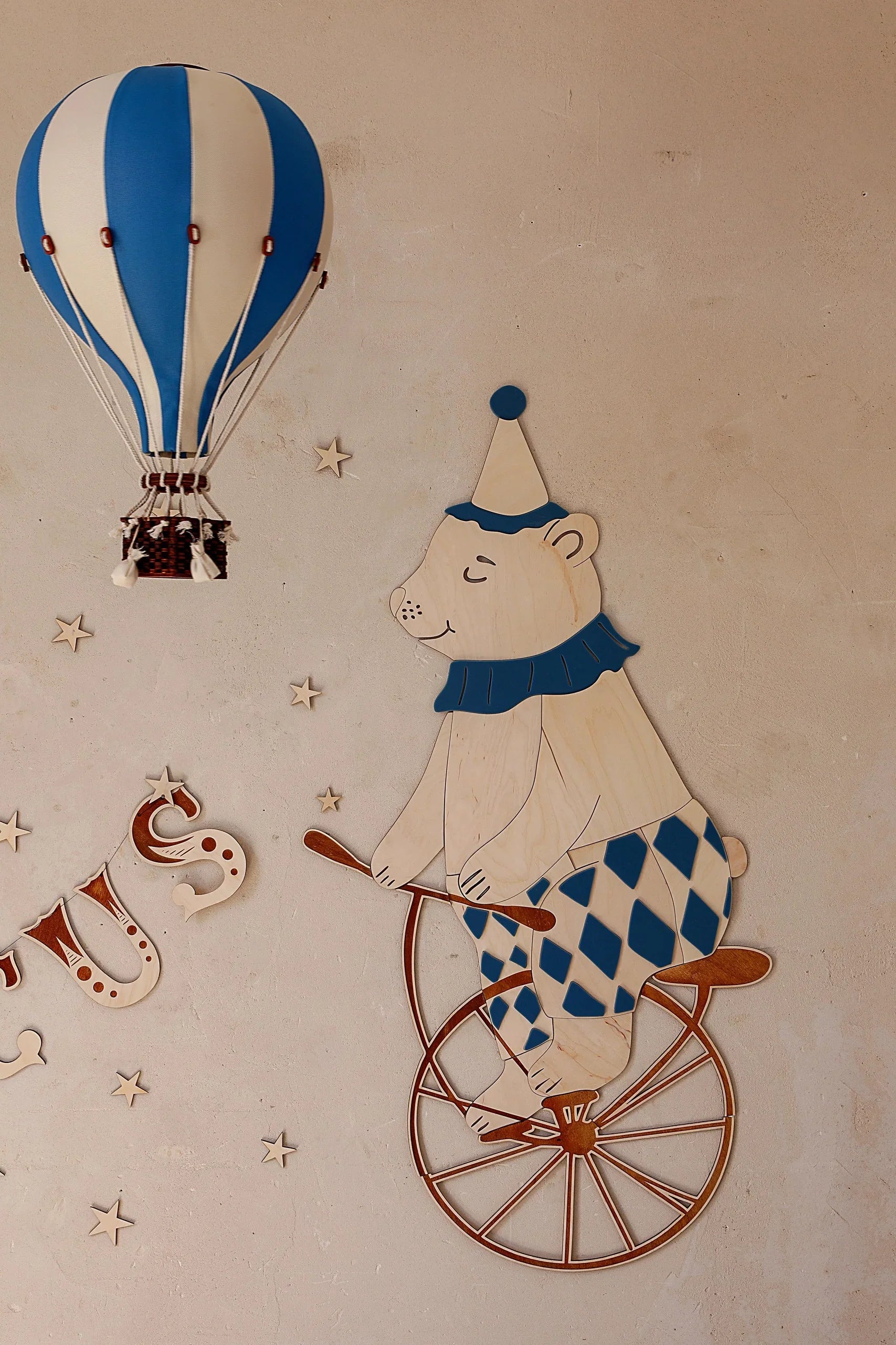 Décoration murale ours de cirque en bois sur monocycle avec accents bleus et montgolfière