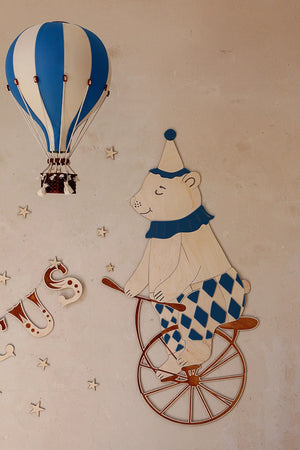 Décoration murale ours de cirque en bois sur monocycle avec accents bleus et montgolfière