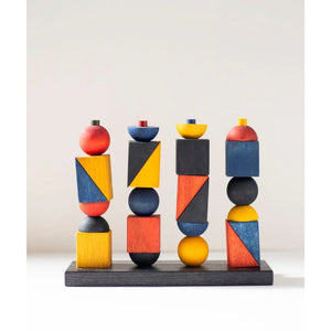 Jeu d'empilement et d'équilibre géométrique en bois coloré sur base noire, conçu pour la coordination Montessori et le jeu sans écran.