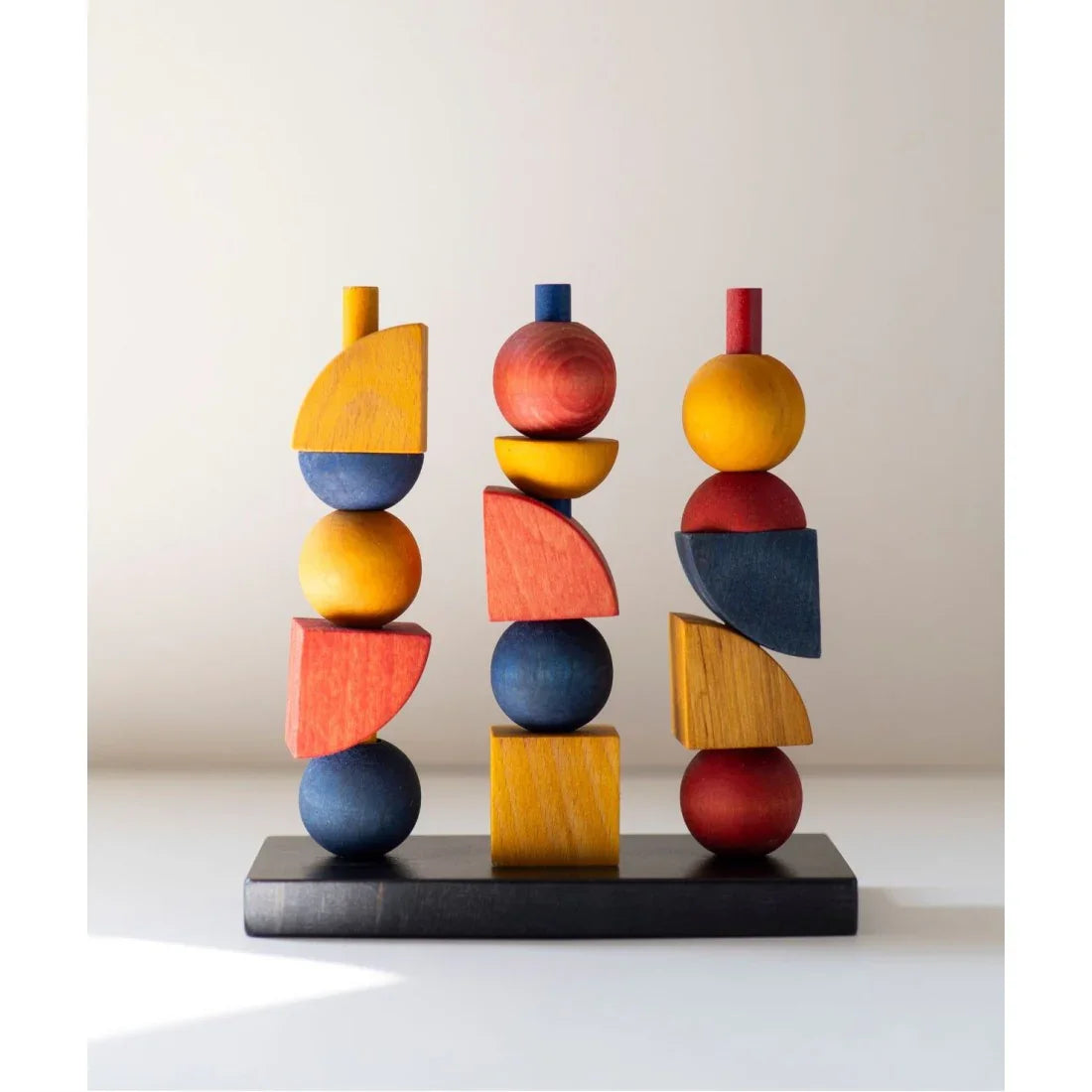 Colorful wooden stacking and balance toy with geometric shapes, designed for Montessori-inspired learning, coordination, creativity and screen-free play.