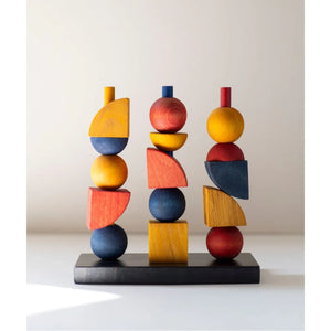 Handcrafted wooden geometric sculpture with colorful stacked shapes on black base, modern nursery decor