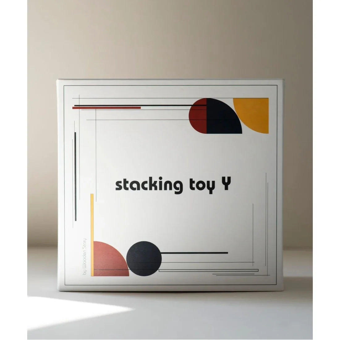 Stacking toy Y by Wooden Story, modern geometric design in red, black, yellow, and terracotta on white box