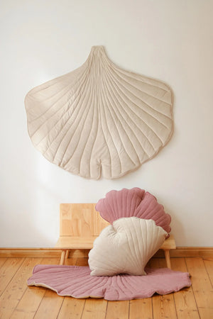 Cream Ginkgo Leaf Mat styled above pink floor mat and coordinating shell cushions in a children’s room
