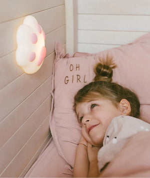 Children's pink paw print night light on wall, girl in pink bedding, nursery decor