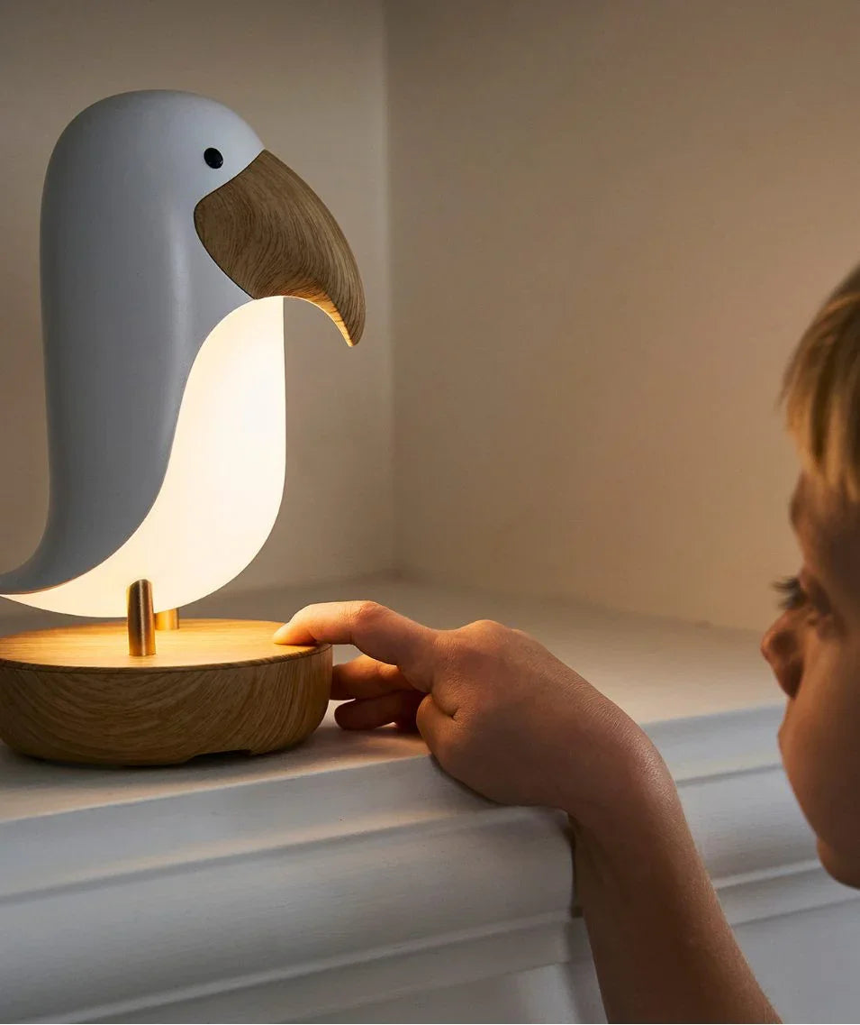 Toucan-shaped nursery night light with wooden base and beak, soft white glow