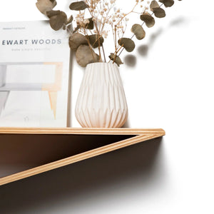 Moderna mensola fluttuante da parete in legno con finitura naturale, decorata con un vaso e un libro
