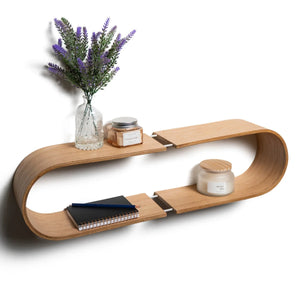 Mensola fluttuante da parete ovale con finitura naturale curva, che espone un vaso di lavanda, candele e taccuini