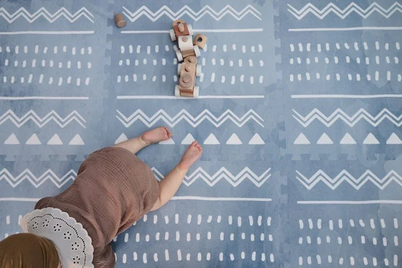 Tapis de jeu puzzle en mousse boho azur avec motif géométrique blanc dans une chambre d'enfant