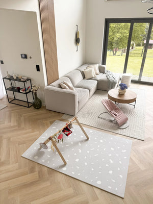 Tapis de jeu puzzle en mousse terrazzo lavande avec motif géométrique blanc dans un salon moderne