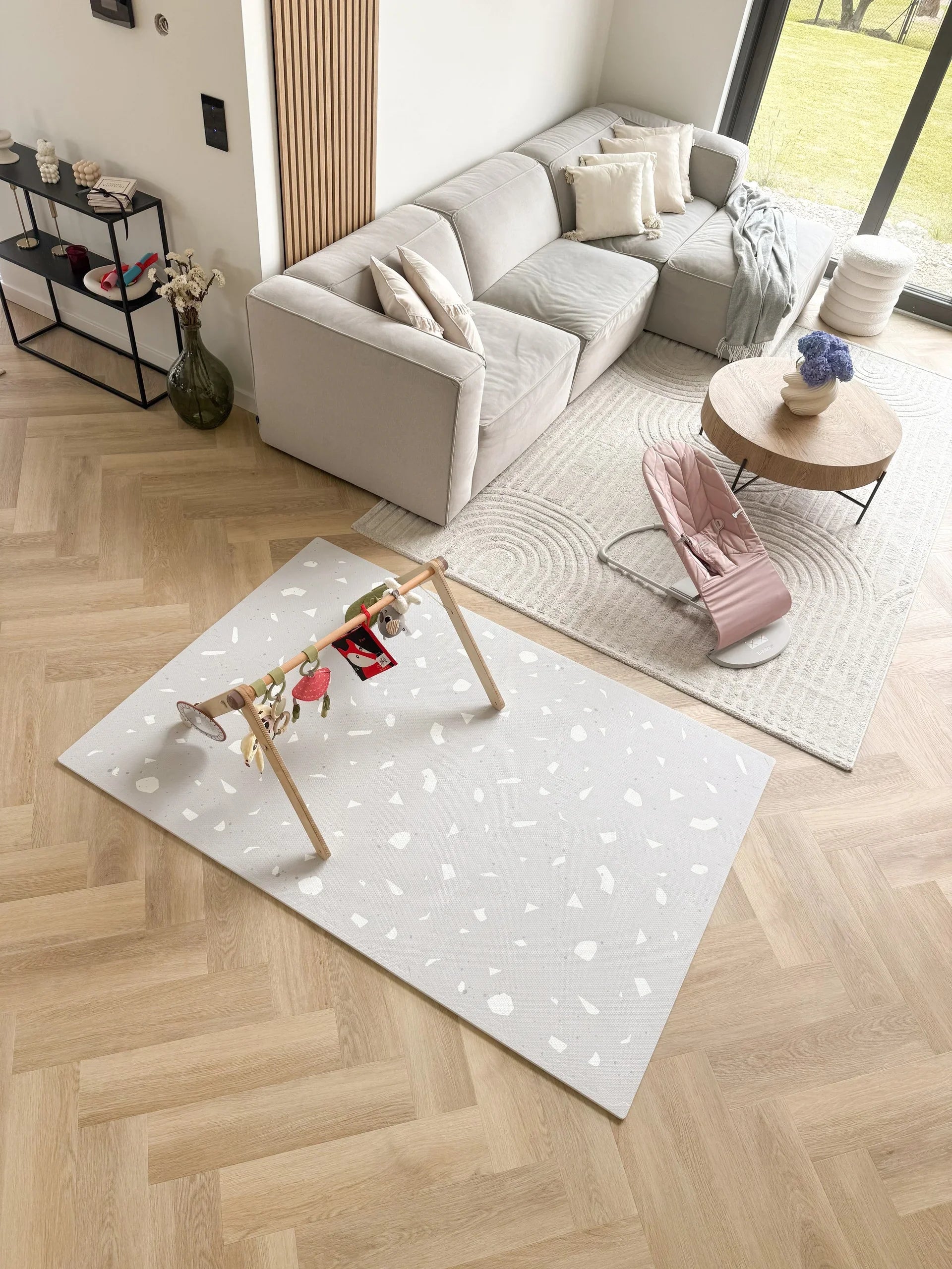 Tapis de jeu puzzle en mousse lavande à motif terrazzo sur parquet dans un salon moderne