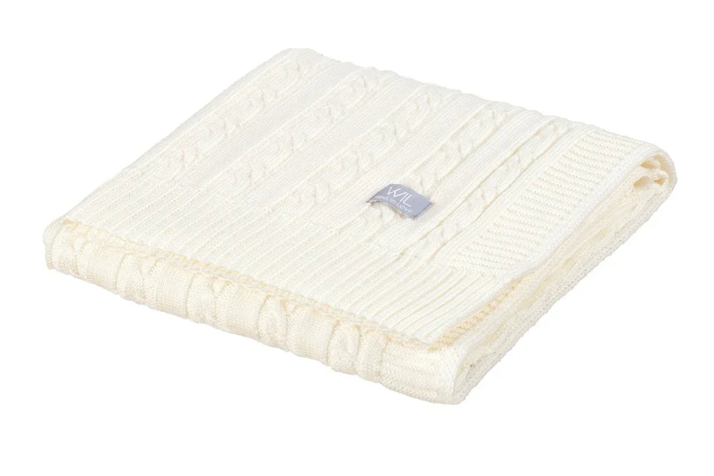 Couverture bébé en tricot torsadé blanc pliée avec motif texturé et tissu doux