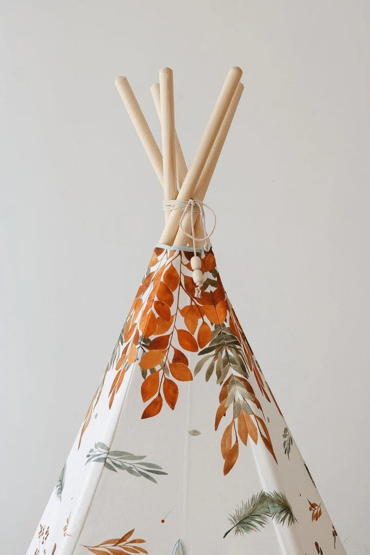Close-up of natural pine teepee poles and orange woodland leaves on the Forest Friends fabric