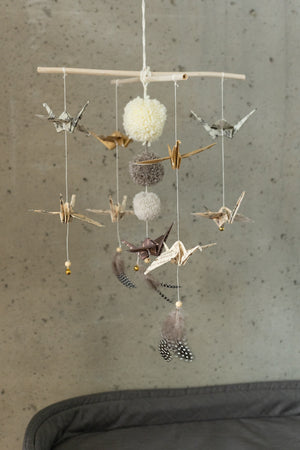 Full view of the Moi Mili Gold Dust mobile with paper birds, pompoms and feathers