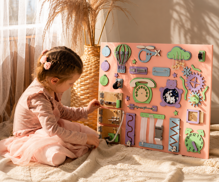 Young boy playing with wooden blocks on a rug next to the text "Learn Through Play – Beautifully chosen toys and childhood essentials"