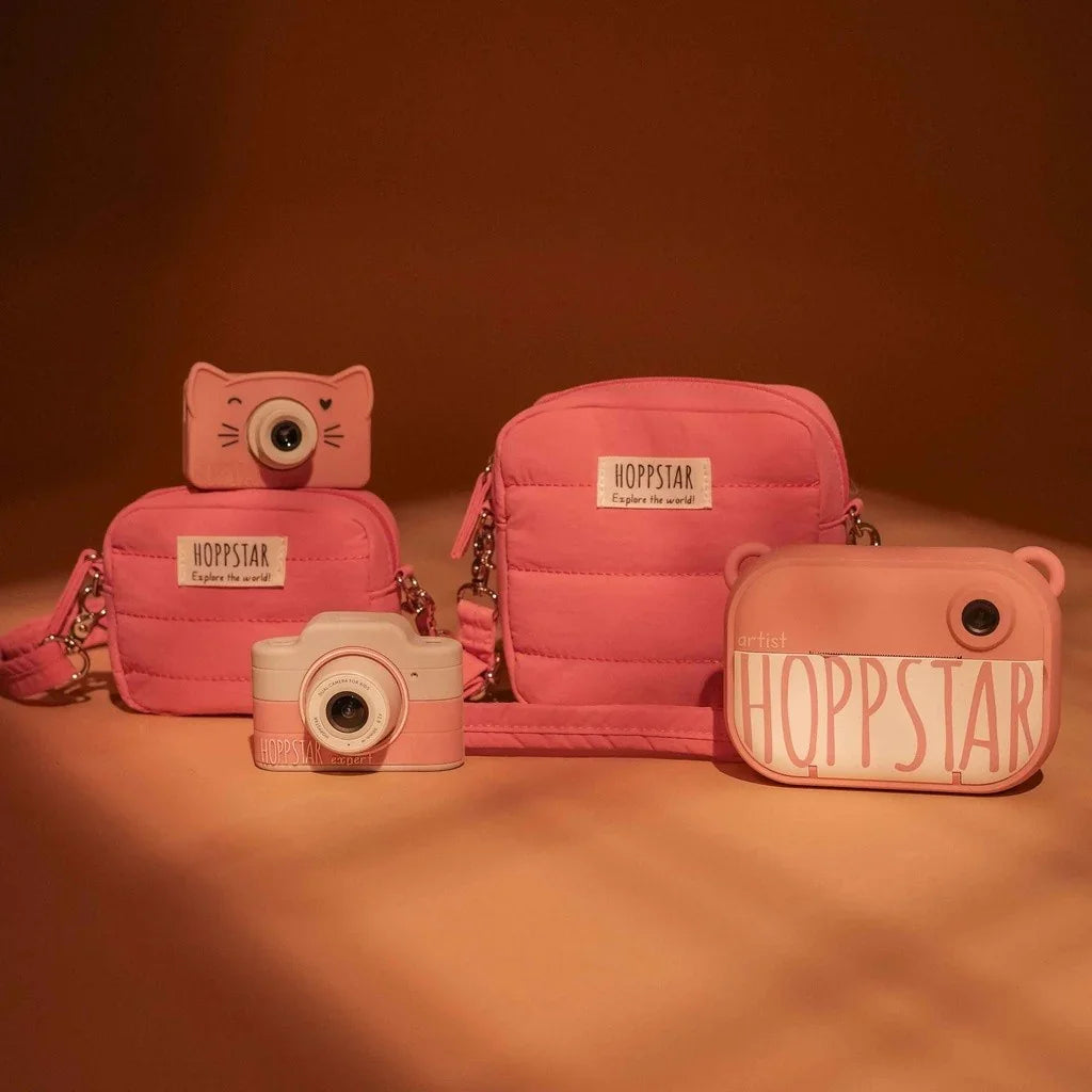 Borse fotografiche e fotocamere giocattolo Hoppstar rosa, con design trapuntato e forme divertenti su sfondo marrone