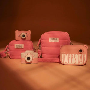 Borse fotografiche e fotocamere giocattolo Hoppstar rosa, con design trapuntato e forme divertenti su sfondo marrone