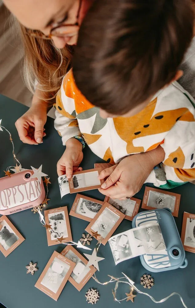 Enfant et adulte jouant au jeu de mémoire Hoppstar avec cartes photo imprimées et décorations étoiles