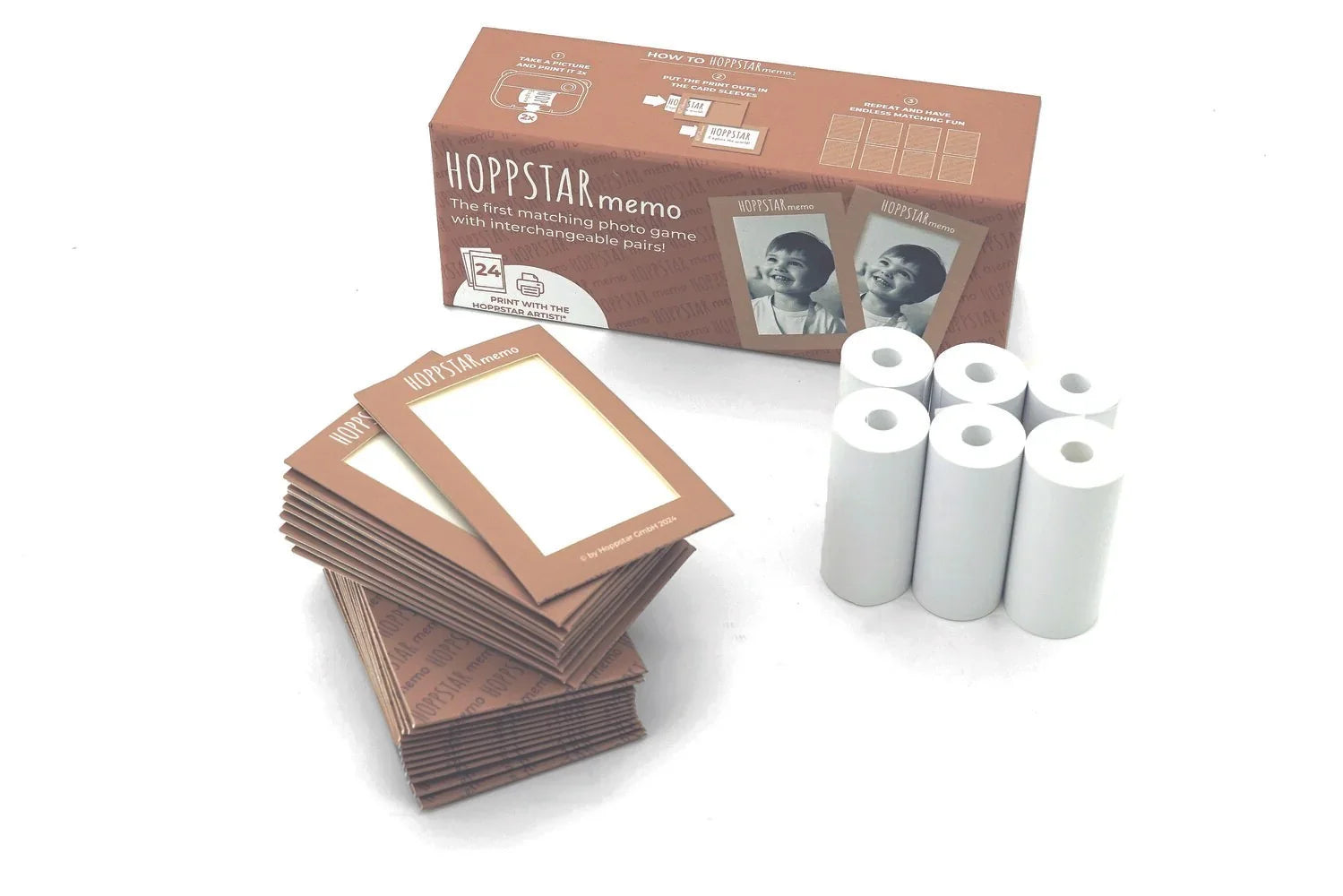 Set de juego de memoria a juego Hoppstar con marcos de tarjetas marrones y rollos de papel blanco.