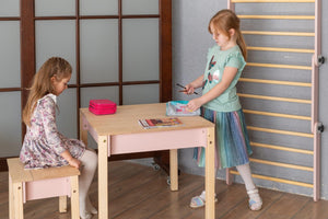 Two children using pink Smart Storage Table and Chair for drawing and school activities