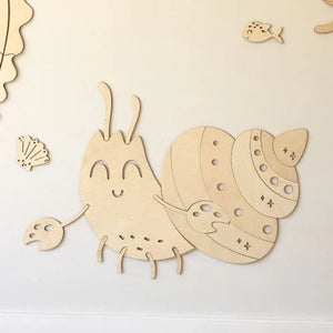Decoración de pared de caracol en madera natural con detalles cortados a láser, ideal para habitación infantil.