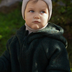 Toddler in olive green hooded fleece jacket and gray knit beanie, outdoor nursery wear