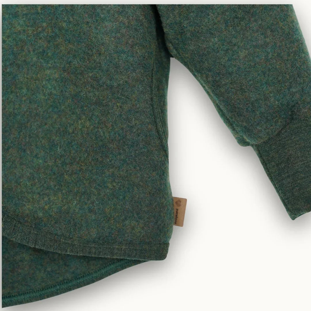 Forest green organic cotton baby onesie with ribbed cuffs and neckline, featuring a natural fabric tag.