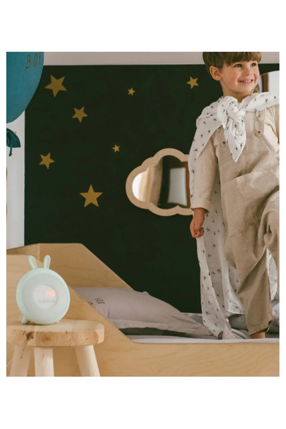 blue bunny-shaped kids alarm clock with night light on wooden stool in nursery bedroom