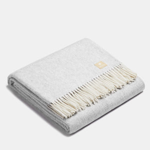 Couverture jetée en laine ALPAKA gris clair et blanc à motif chevrons premium, motif arête de poisson et franges blanches classiques