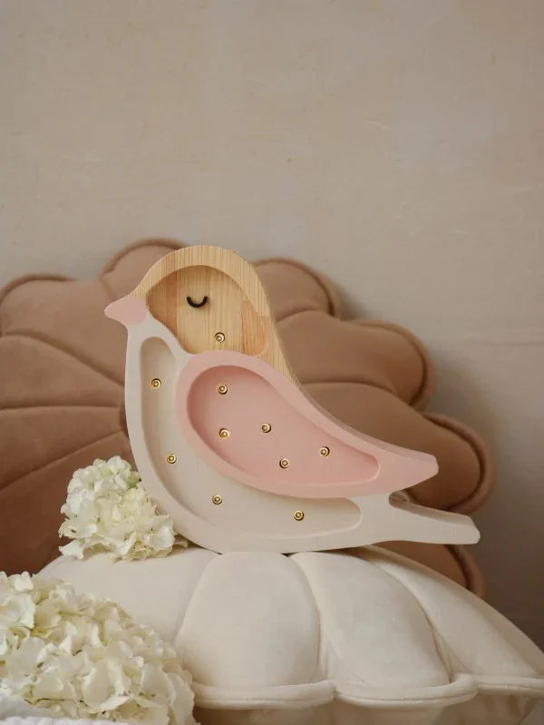 Wooden bird nightlight with pink accents and gold dots, displayed on nursery decor