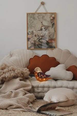 Wooden bird night light with warm LEDs, shell-shaped pillows, floral wall art, cozy nursery decor