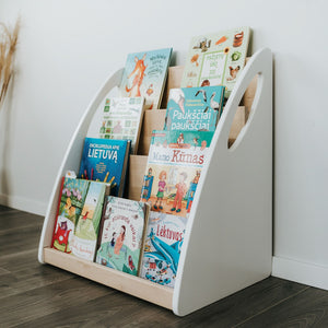 One Little Pine four-shelf Montessori bookshelf filled with front-facing children’s books in white and natural wood