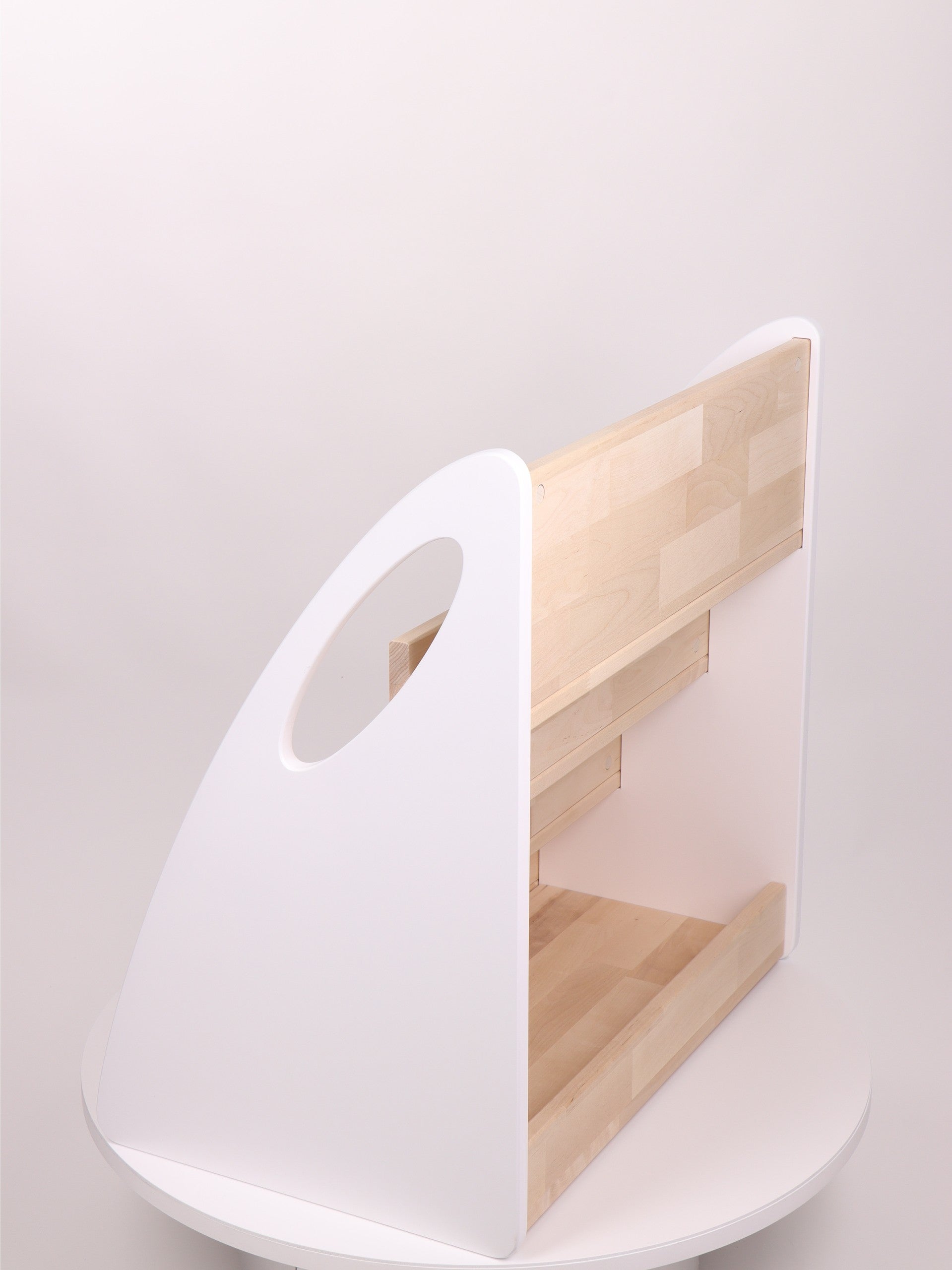 Rear product view of white and natural wood Montessori bookshelf showing additional storage compartment