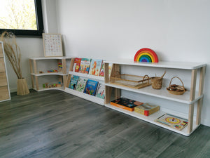 Wide Montessori learning space with two-shelf bookcase connected to low modular storage furniture
