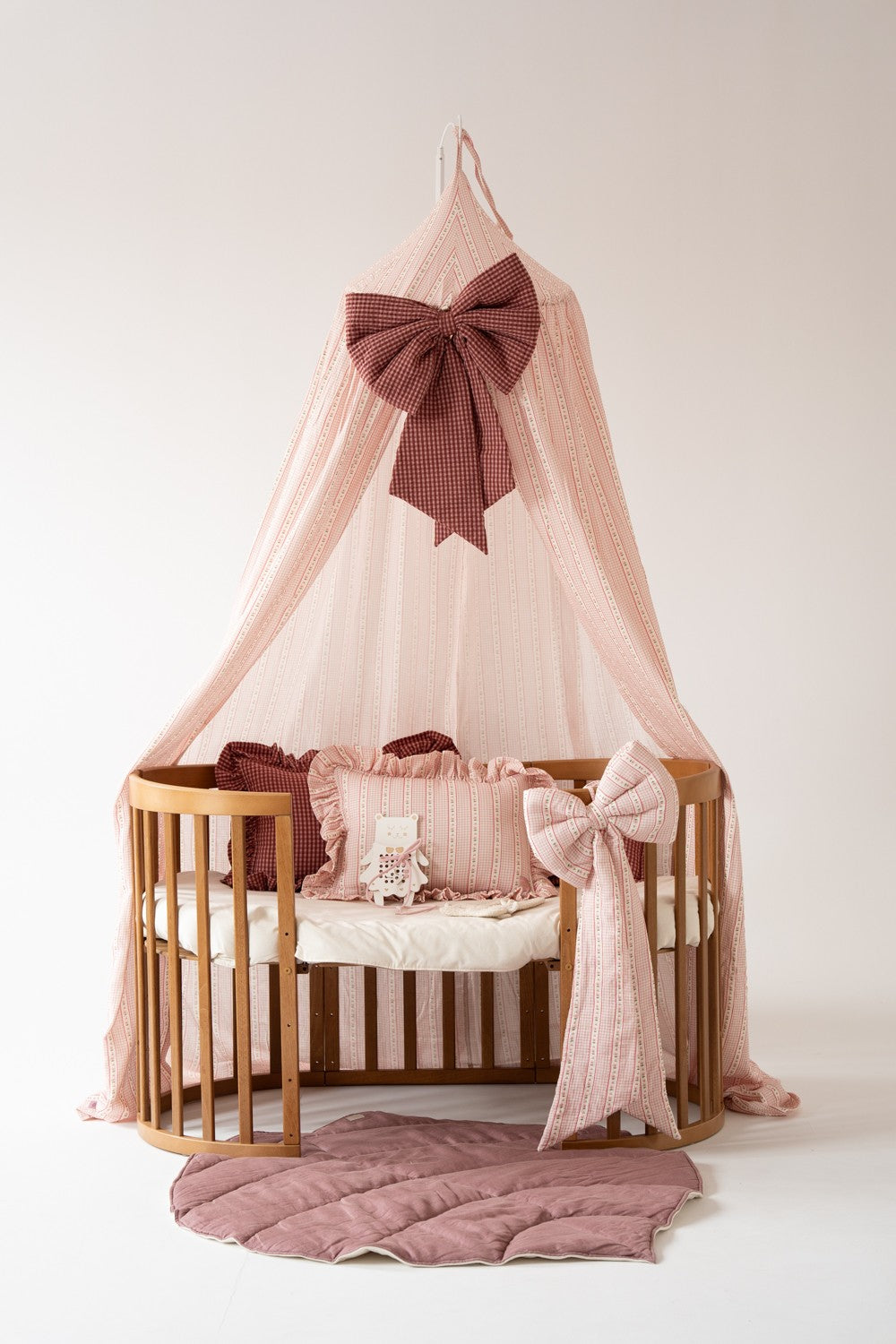 Vintage striped children’s canopy styled with ruffled cushions, decorative bow and dusty pink quilted play mat