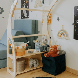 Close-up of Montessori Play Stand shelf with books, baskets and soft toys