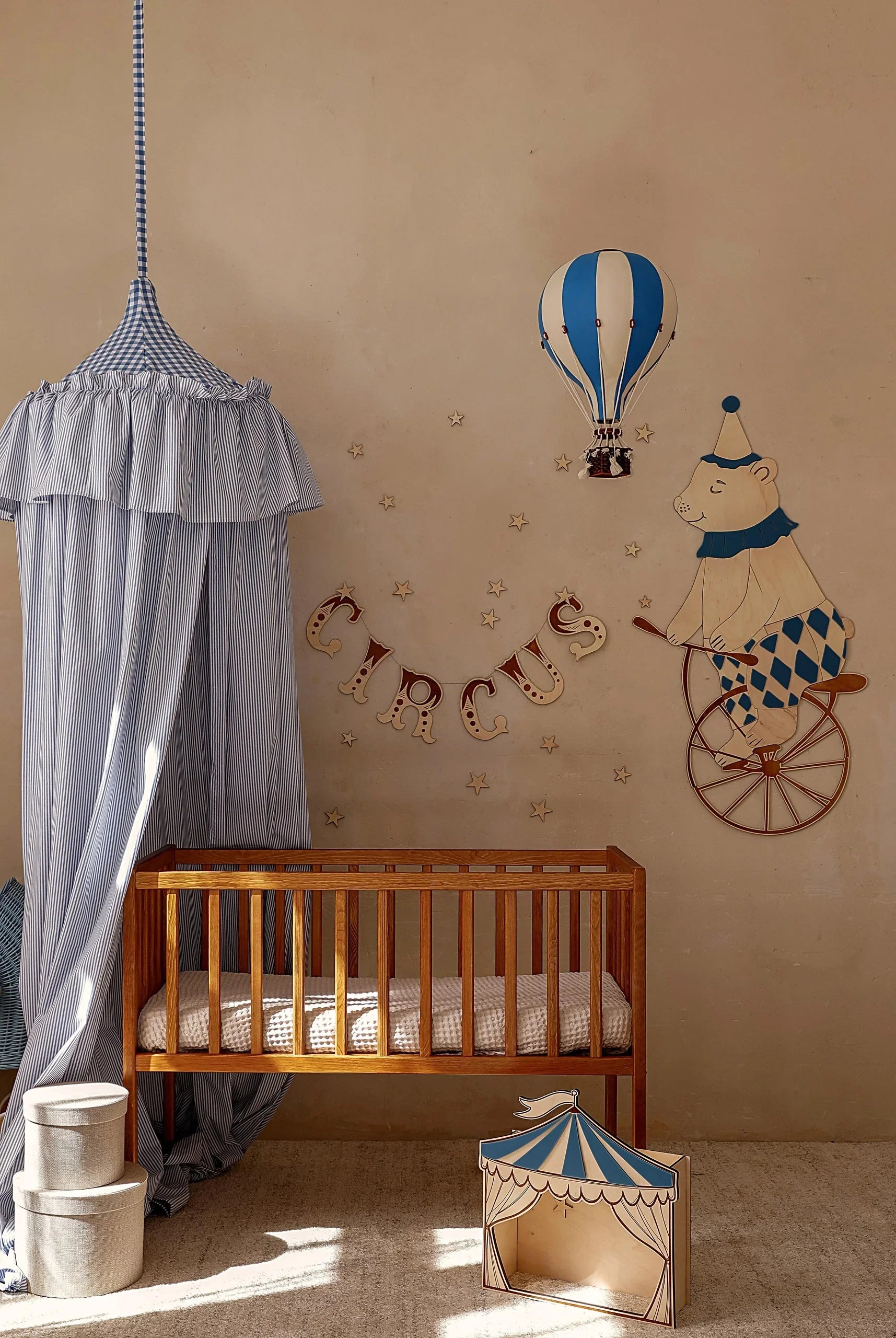 Decorazione da parete per nursery in legno raffigurante un orso su una bici da circo, una mongolfiera blu e stelle sopra la culla