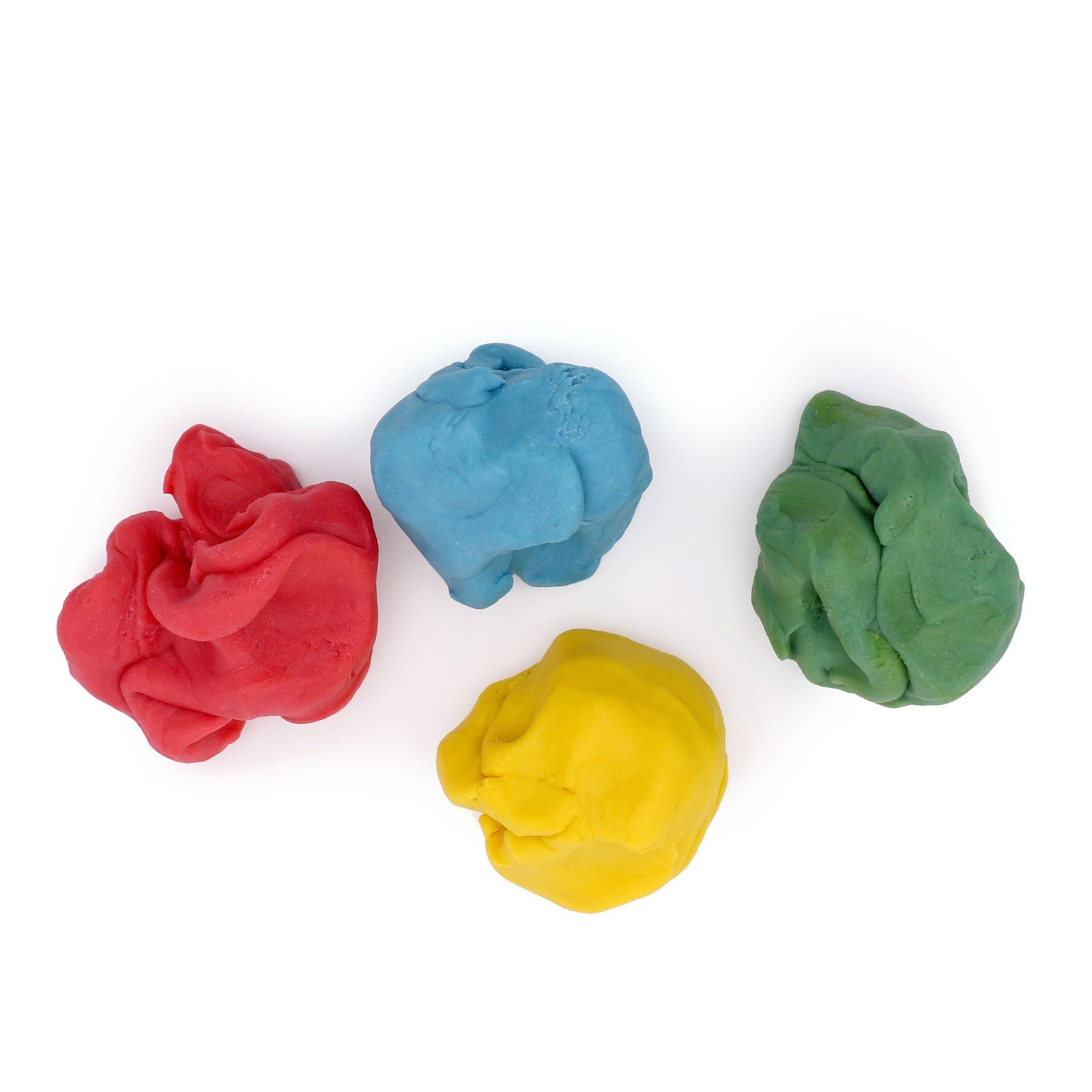 Four loose pieces of Neogrün modelling clay in red, blue, yellow and green on a white background
